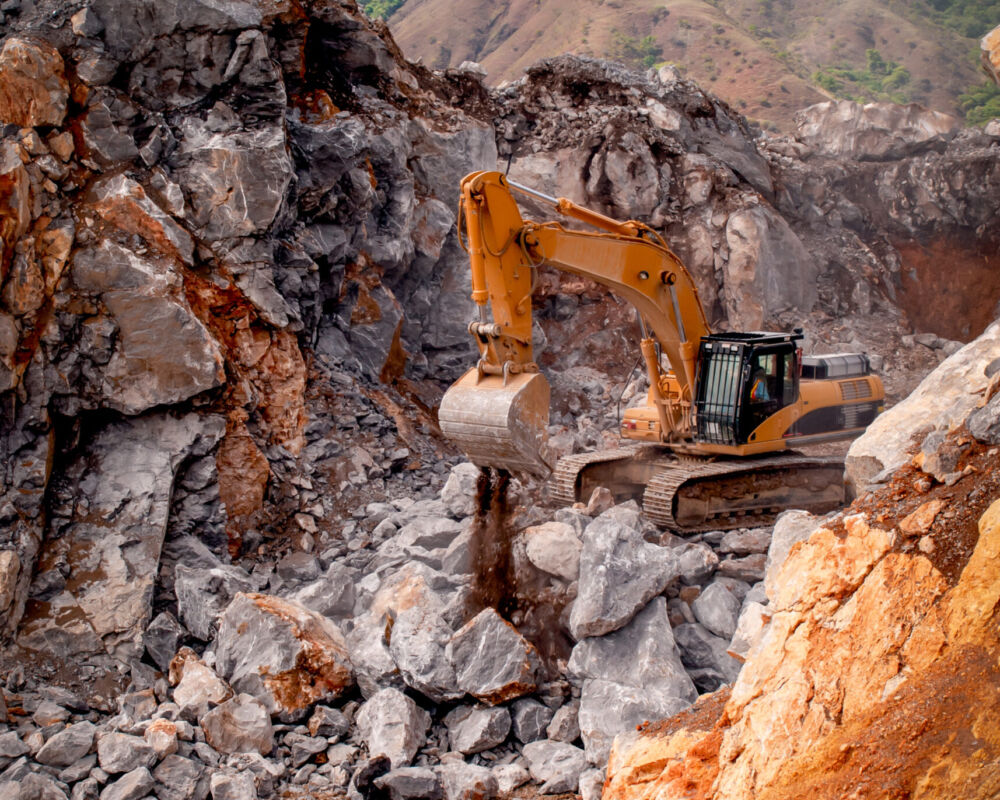 Excavator working in a limestone quarry to extract raw material for cement production